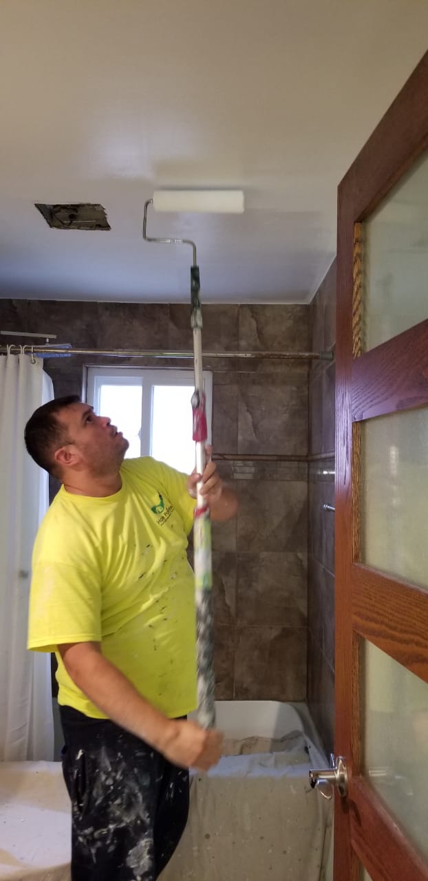 interior painting on a ceiling and painting white wall using roller by home painters toronto