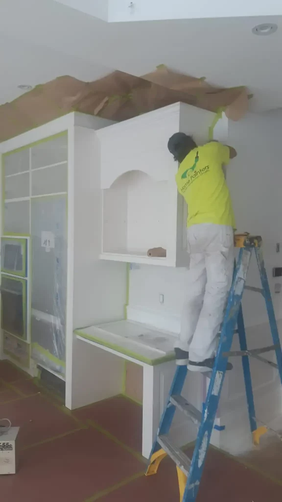 painter painting cabinet with ladder home painters toronto