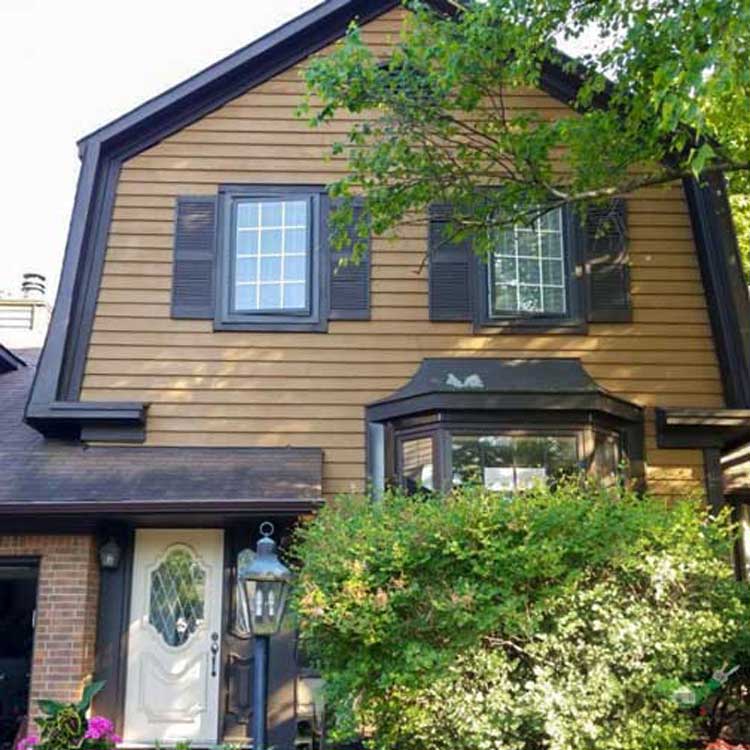 cottage style home with brown exterior aluminum siding and wood window trim painted charcoal to improve curb appeal home painters toronto