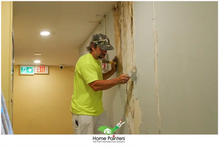 Painter Sanding The Drywall