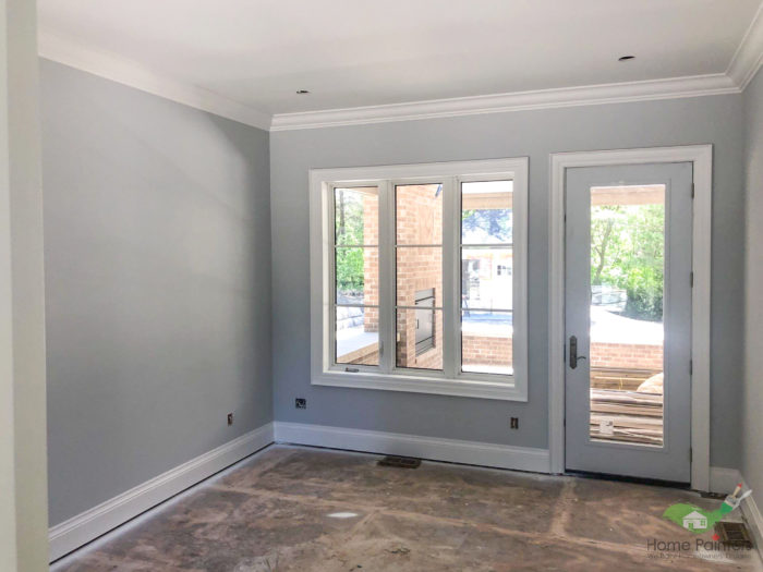 renovated room painted light grey with white trim around the door and windows