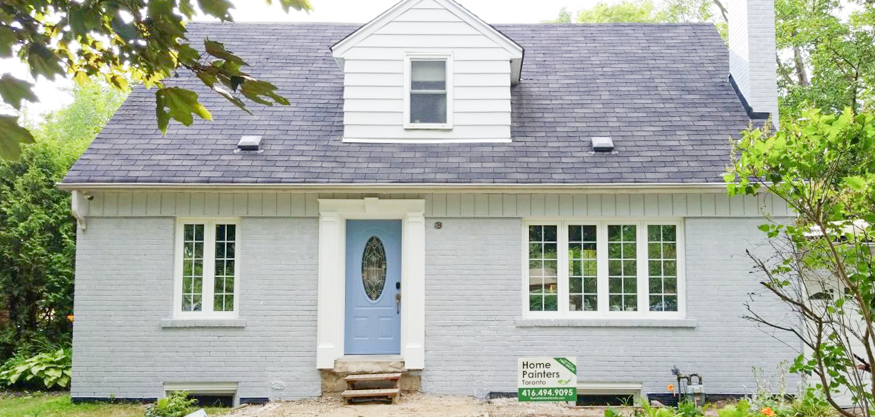 Beautiful classic canadian home with a brick stain job in blue gray colour, white window frames and dark gray roof, done by home painters toronto Toronto painting company