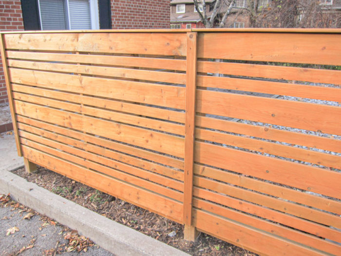orange wood plank fence around brick house, house painters