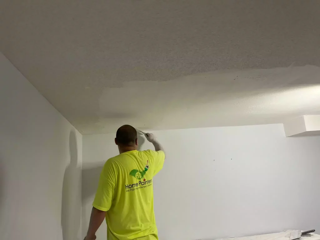 painter flattening the stucco ceiling