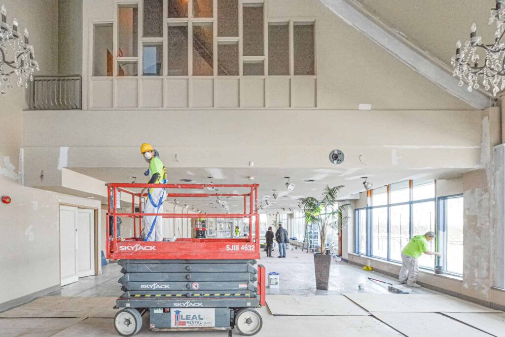 Commercial Painting Worker On Lift Painting Ceiling