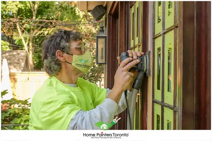 Painter Sanding A Wood Window