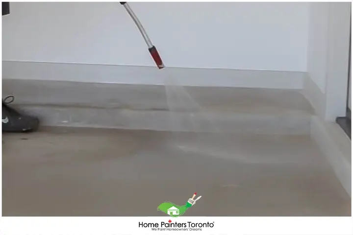 Painter Cleaning Walls And Floors Of Garage