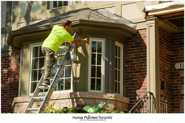 painter painting a wood window