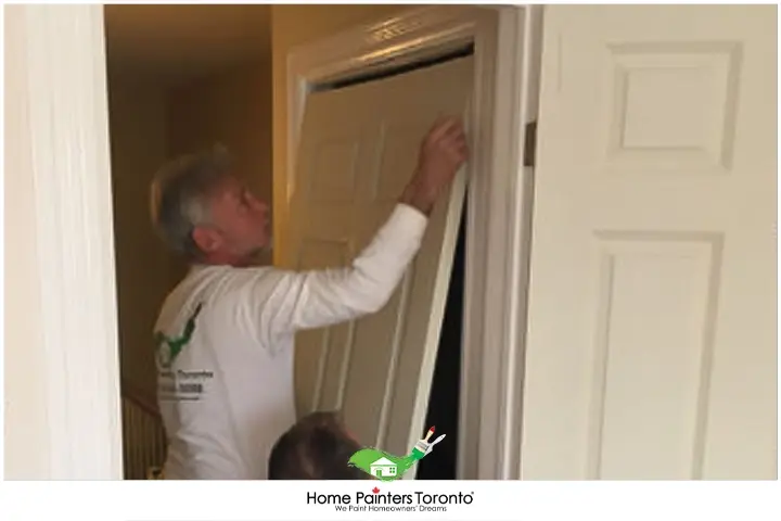 Painter Replacing Metal Door With Wood