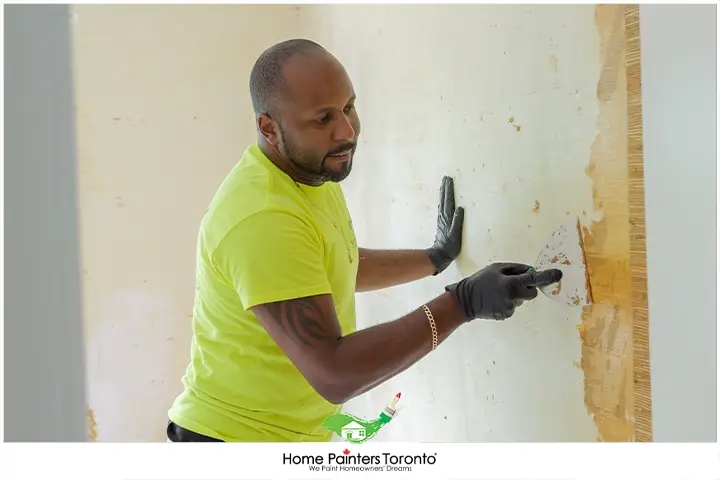 Painter Scraping Old Wallpaper