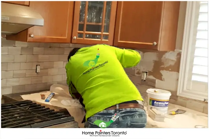 Painter Installing Tile Backsplash