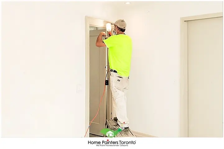 Painter Repairing a Door with White Wall